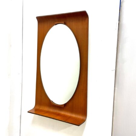 Specchio ovale anni ’50 con supporto in legno curvato rettangolare.