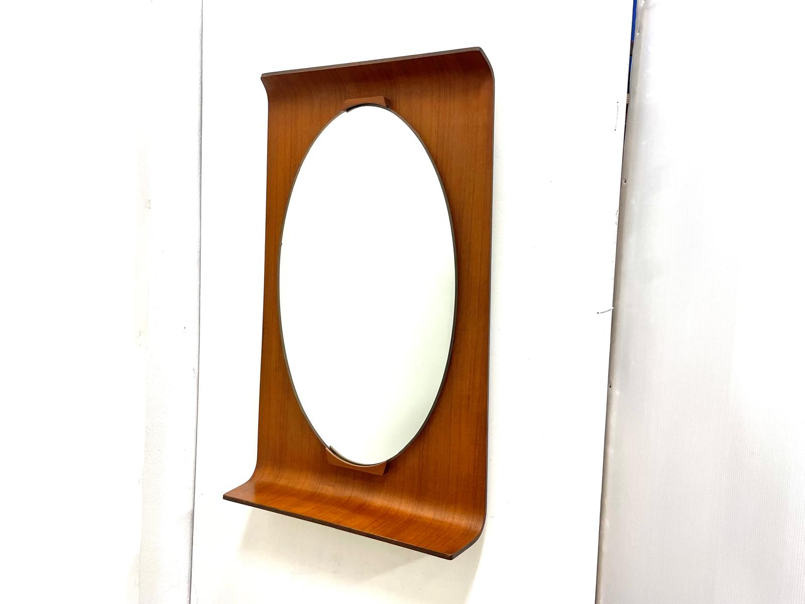 Specchio ovale anni ’50 con supporto in legno curvato rettangolare.